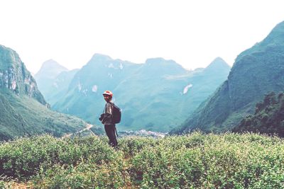 Woman standing on mountain against sky