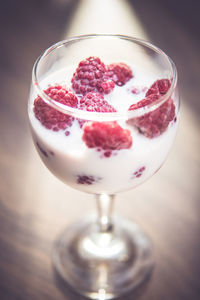 Close-up of fresh raspberries in milk glass