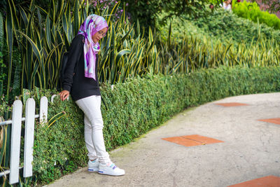 Portrait of woman standing on footpath