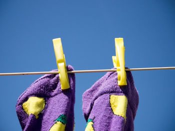 Low angle view of clothes hanging on clothesline against blue sky