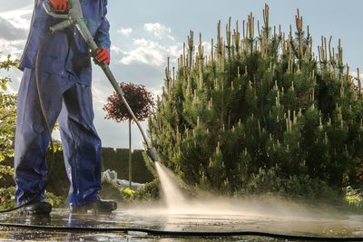 Low section of man spraying water