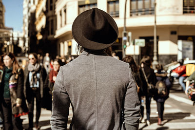 Rear view of man walking on street in city