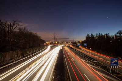 High angle view of light trails on highway against sky at dusk