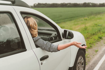 Reflection of woman on car mirror