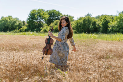 Portrait of smiling young woman standing on field