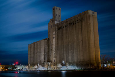 View of building against cloudy sky at night