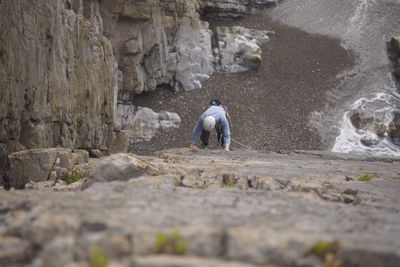 Rear view of men walking on rock