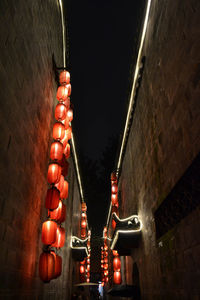 Low angle view of illuminated lanterns hanging on wall