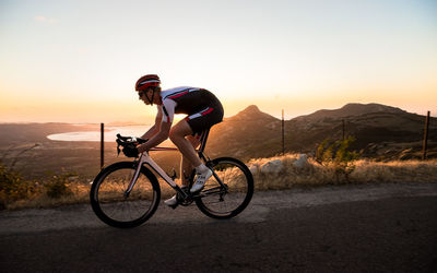 Man riding bicycle on road against sky