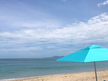 Scenic view of beach against blue sky