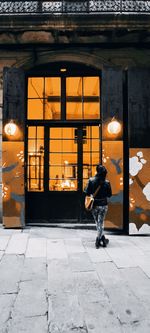 Rear view of woman walking in illuminated building