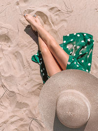 Low section of woman lying on sand