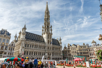 Group of people in front of buildings against sky