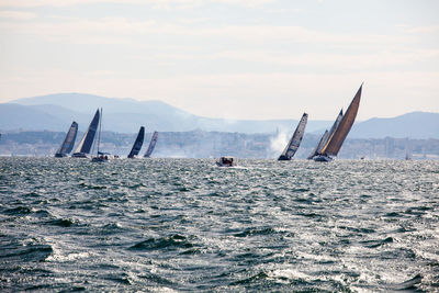 View of sailboat in calm sea against mountain range