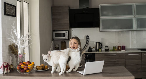 Portrait of woman working at home with cats