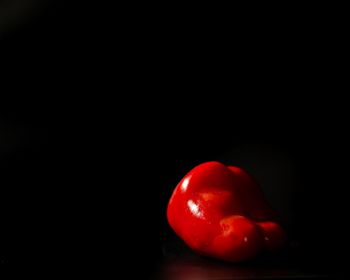 Close-up of red fruit over black background