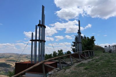 Metallic structure on field against sky