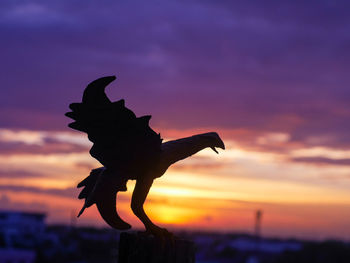 Close-up of silhouette statue against sky during sunset