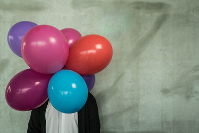 Close-up of multi colored balloons against wall