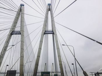 Low angle view of suspension bridge against sky