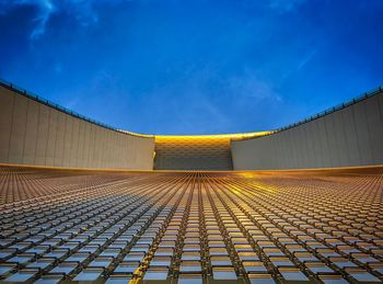 Low angle view of illuminated modern building against blue sky