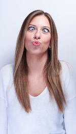 Portrait of beautiful young woman against white background