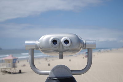 Close-up of coin-operated binoculars against sky