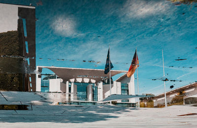 Road by buildings in city against sky