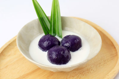 Kolak candil ubi ungu or purple sweet potato balls with palm sugar and coconut milk sauce.