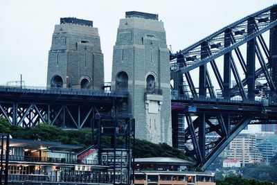 Low angle view of bridge over river against buildings in city