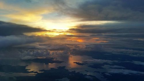 Scenic view of sea against cloudy sky at sunset