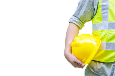 Midsection of man holding yellow while standing against white background