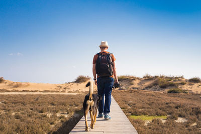 Rear view of man walking on road