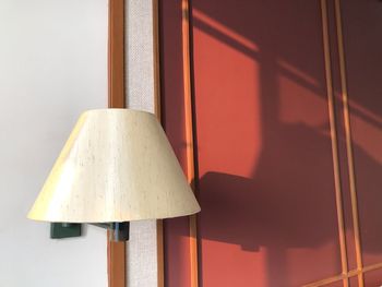 Close-up of electric lamp against wall at home