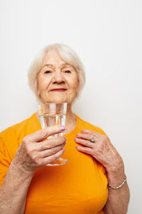 Young woman drinking juice against white background