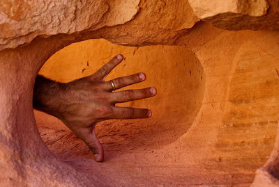 Human hand touching rock formation
