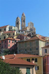 Buildings in city against clear blue sky