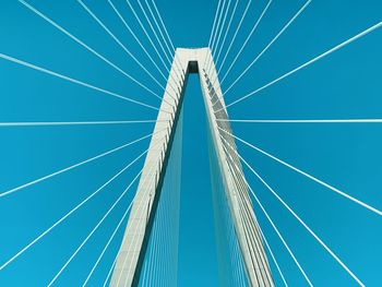 Low angle view of suspension bridge against blue sky