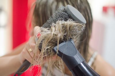 Close-up of woman drying hair with dryer