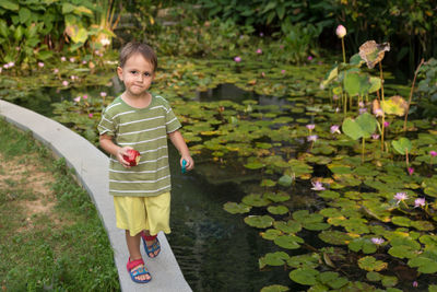 Portrait of smiling boy standing by plants