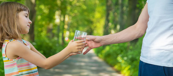 Girl passing drinking water to mother