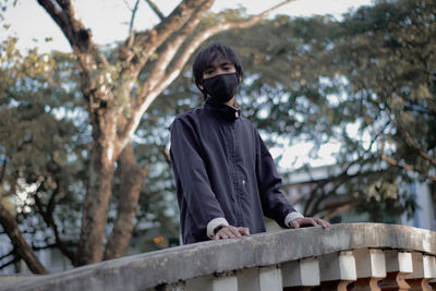 Low angle view of man standing against trees