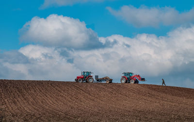 Low angle view of tractor on field against sky