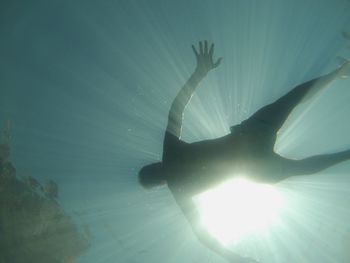Close-up of silhouette swimming underwater