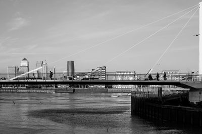 Bridge over river in city against sky