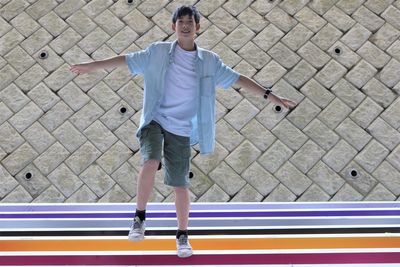 Full length of man standing against wall