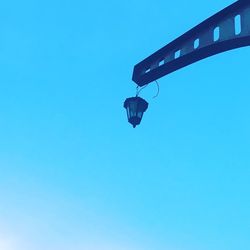 Low angle view of telephone pole against clear blue sky