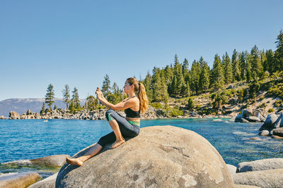 Young woman taking a picture of lake tahoe.