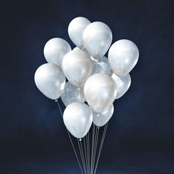 Low angle view of balloons against black background