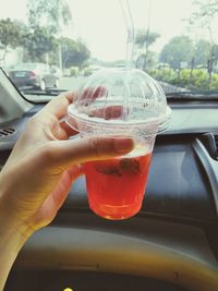 Close-up of woman hand holding glass of car